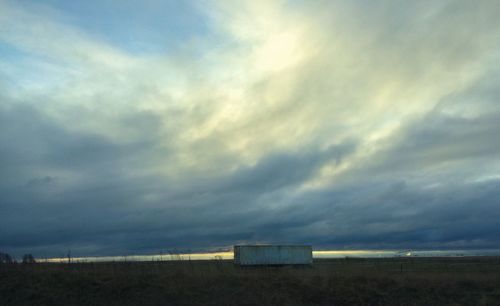 Scenic view of field against cloudy sky