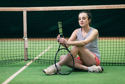 Tennis player sitting on at court