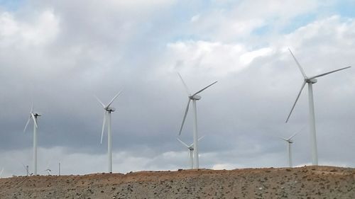 Windmill on field against sky