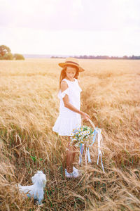 Woman standing on field against sky