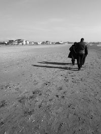 Rear view of man walking on beach