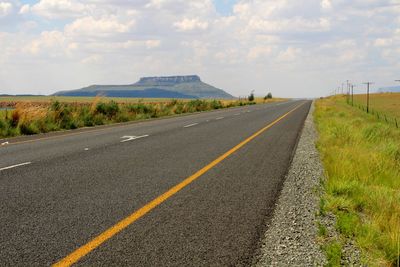 Empty road leading towards sky