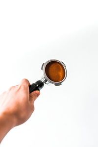 Hand holding coffee cup against white background