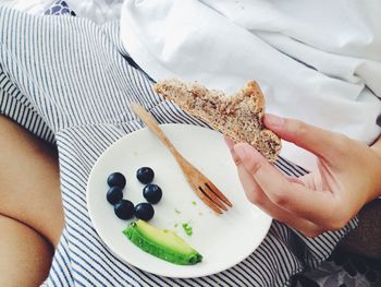 Midsection of person holding bread at home