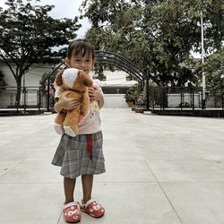 Full length of girl standing against tree