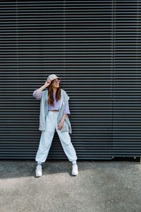 Fashionable funky caucasian girl dancer in sportswear is performing outdoor street dancing motion .