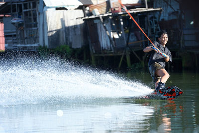 Full length of man jumping on boat in water