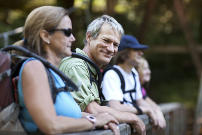 Portrait of mature hiker standing with family in forest