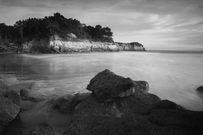 Long exposure photo of a beach, a beach with steep cliffs in indonesia and moving waves