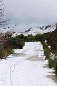 Scenic view of snow covered land against sky