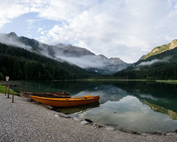 Scenic view of lake by mountains against sky