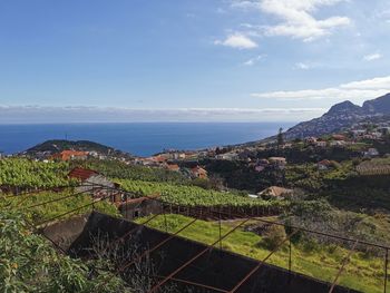 High angle view of townscape by sea against sky