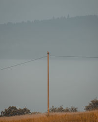 Electricity pylon on land against sky