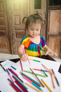 Cute girl drawing on paper at home