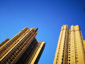 Low angle view of modern buildings against clear blue sky
