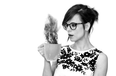 Portrait of woman wearing eyeglasses against white background