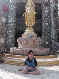 Portrait of a buddha statue against building