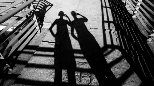 High angle view of silhouette people standing on shadow