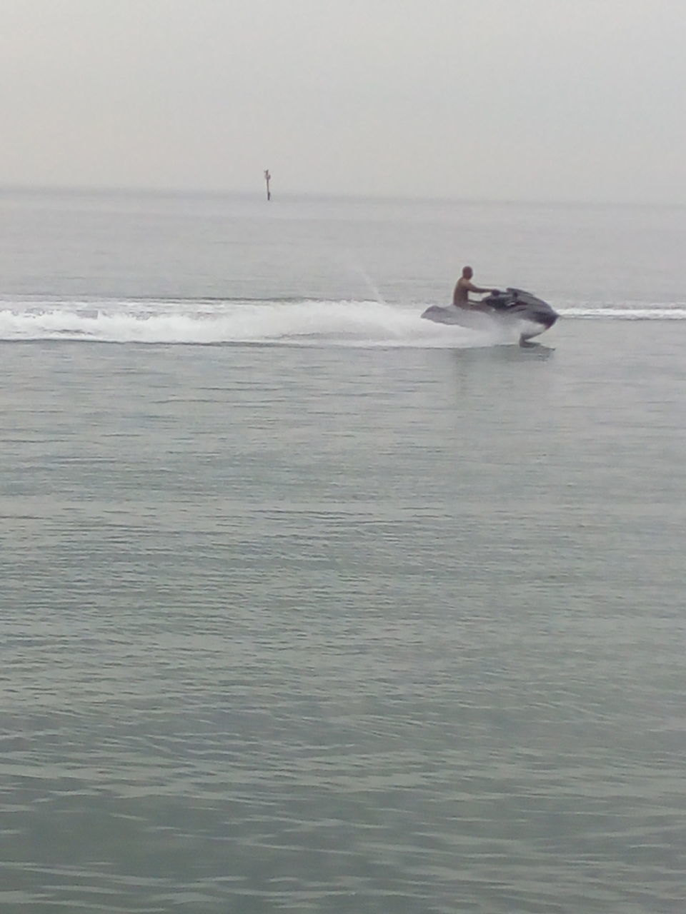 MAN ON BOAT IN SEA AGAINST SKY