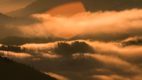 Scenic view of dramatic sky over lake during sunset