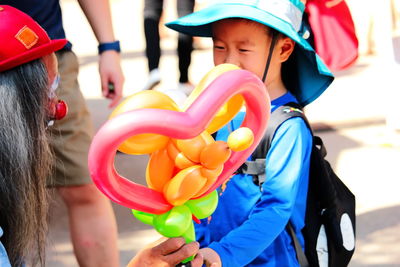 Rear view of people holding multi colored umbrella