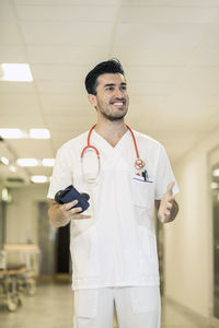 Smiling young male doctor gesturing in hospital