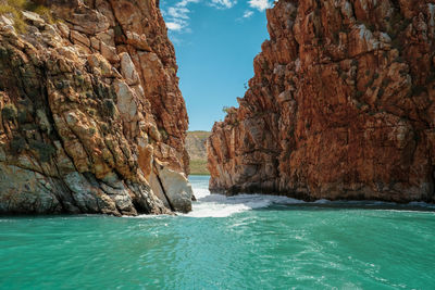 Rock formations in sea against sky