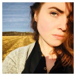 Close-up portrait of young woman against sky