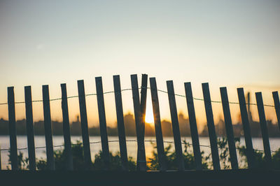 View of fence at sunset