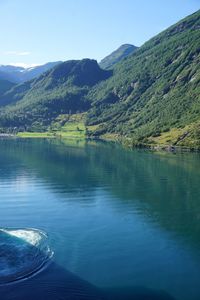 Scenic view of lake by mountains against sky