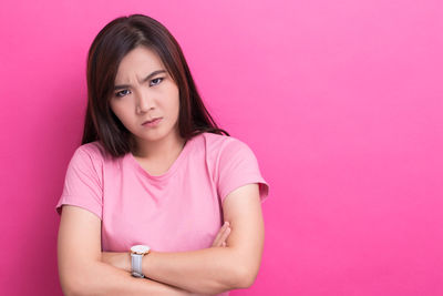 Portrait of beautiful young woman against pink background