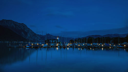 Sailboats moored in marina at dusk