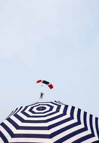 Low angle view of man paragliding against clear sky