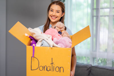 Portrait of young woman holding gift box