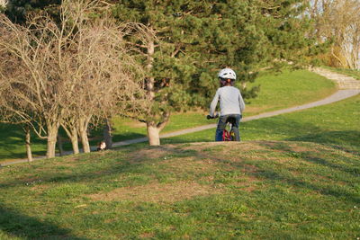 Rear view of girl riding bicycle at park