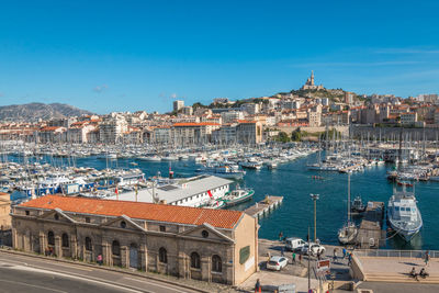 High angle view of buildings by sea against blue sky