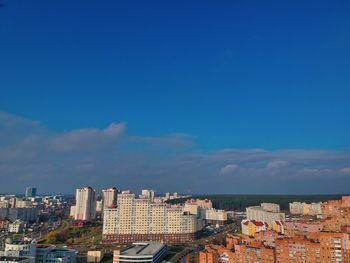 High angle view of buildings against blue sky