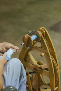 Cropped image of man working with loom in workshop