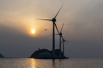 Silhouette of wind turbines at sunset