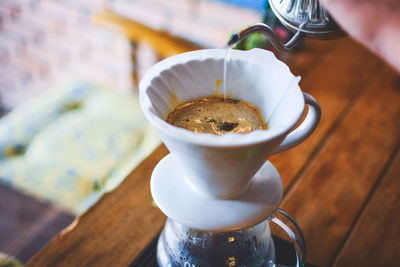 Cropped hand of man preparing coffee on table