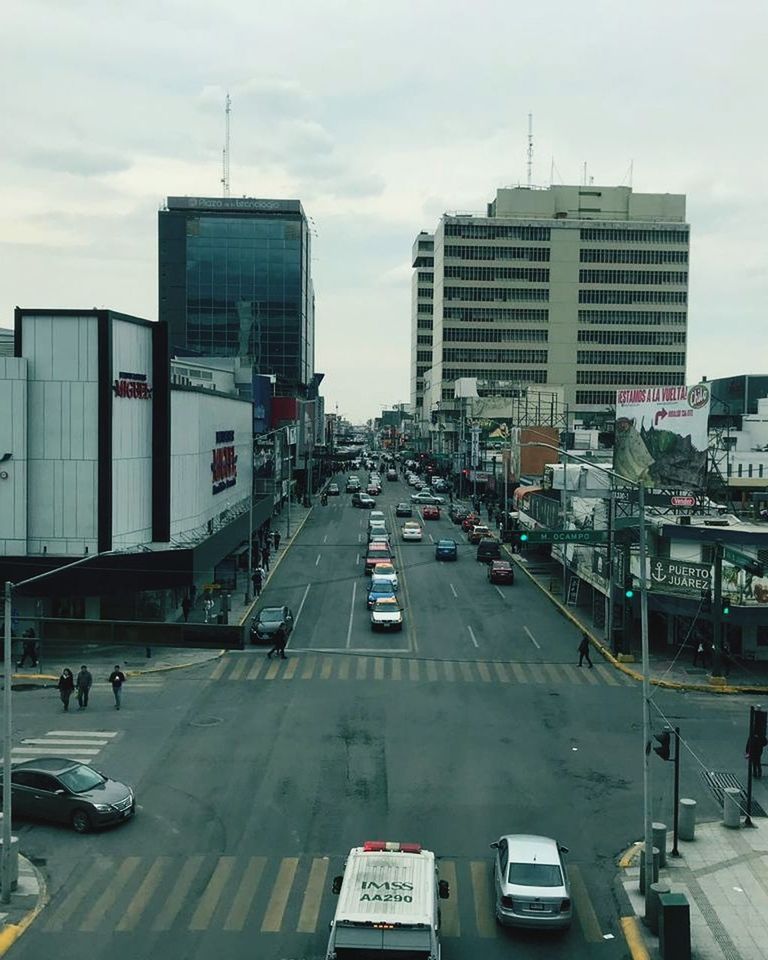 city, transportation, building exterior, architecture, motor vehicle, car, built structure, mode of transportation, road, street, land vehicle, sky, building, day, high angle view, city street, city life, traffic, cloud - sky, outdoors, cityscape, office building exterior, skyscraper