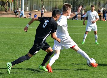 Men playing soccer on field