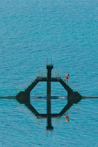 Pier over sea against blue sky