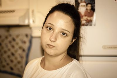 Close-up portrait of a young woman at home
