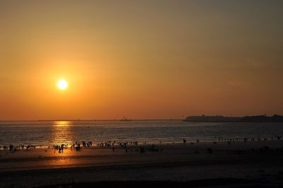 Scenic view of beach against clear sky during sunset