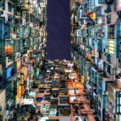 Low angle view of illuminated buildings against sky in city