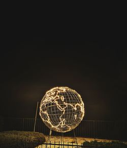 Low angle view of illuminated lighting equipment against sky at night