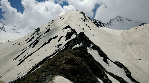 Scenic view of snowcapped mountain against cloudy sky
