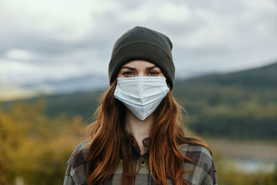 Portrait of beautiful young woman against sky