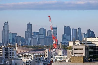 Modern buildings in city against cloudy sky